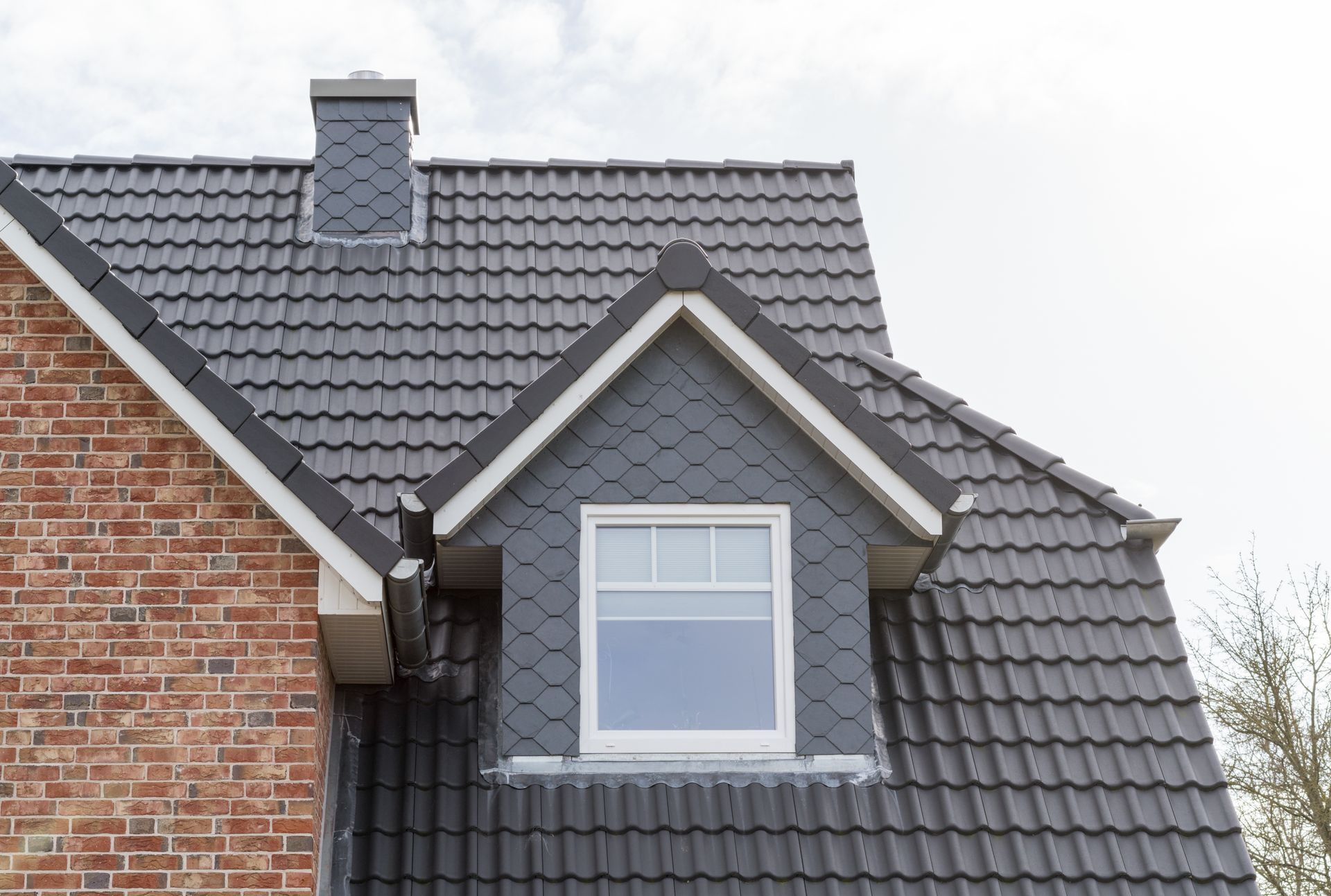 Roof of a home with elegant window showcasing quality work by a trusted residential roofer.