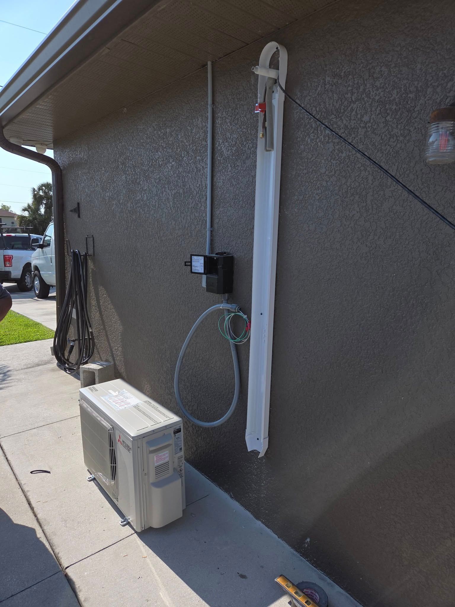 An air conditioner is sitting on the side of a house.