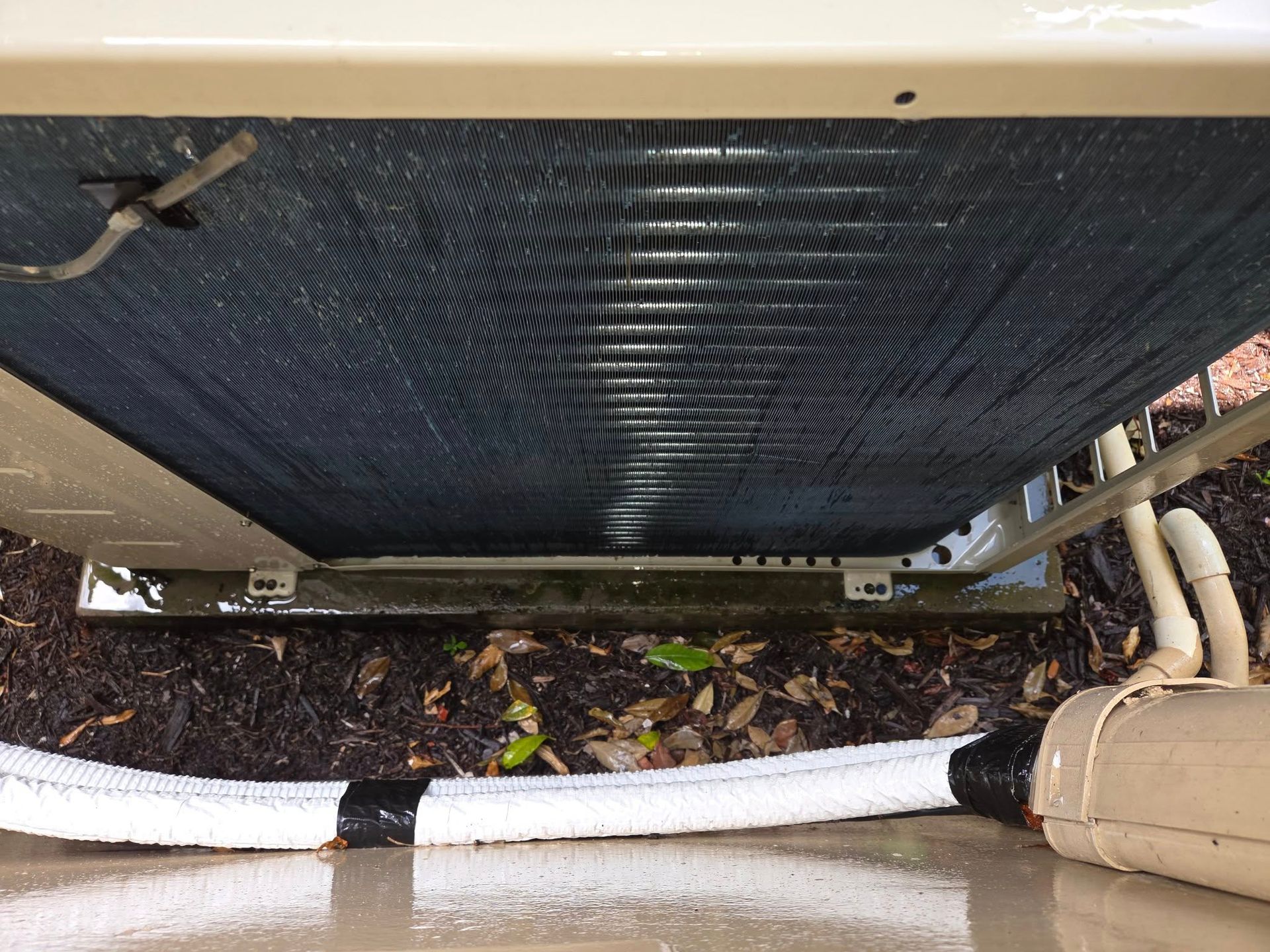 A close up of an air conditioner with a hose attached to it.