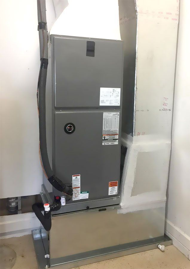 An air conditioner is sitting in a room next to a wall.