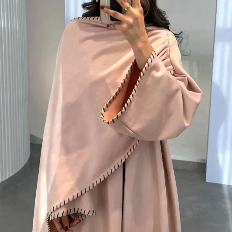 A woman in a pink dress is sitting on a white couch