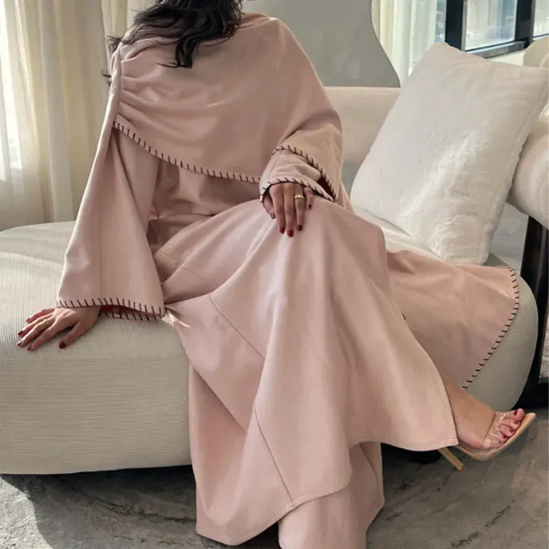 A woman in a pink dress is sitting on a white couch