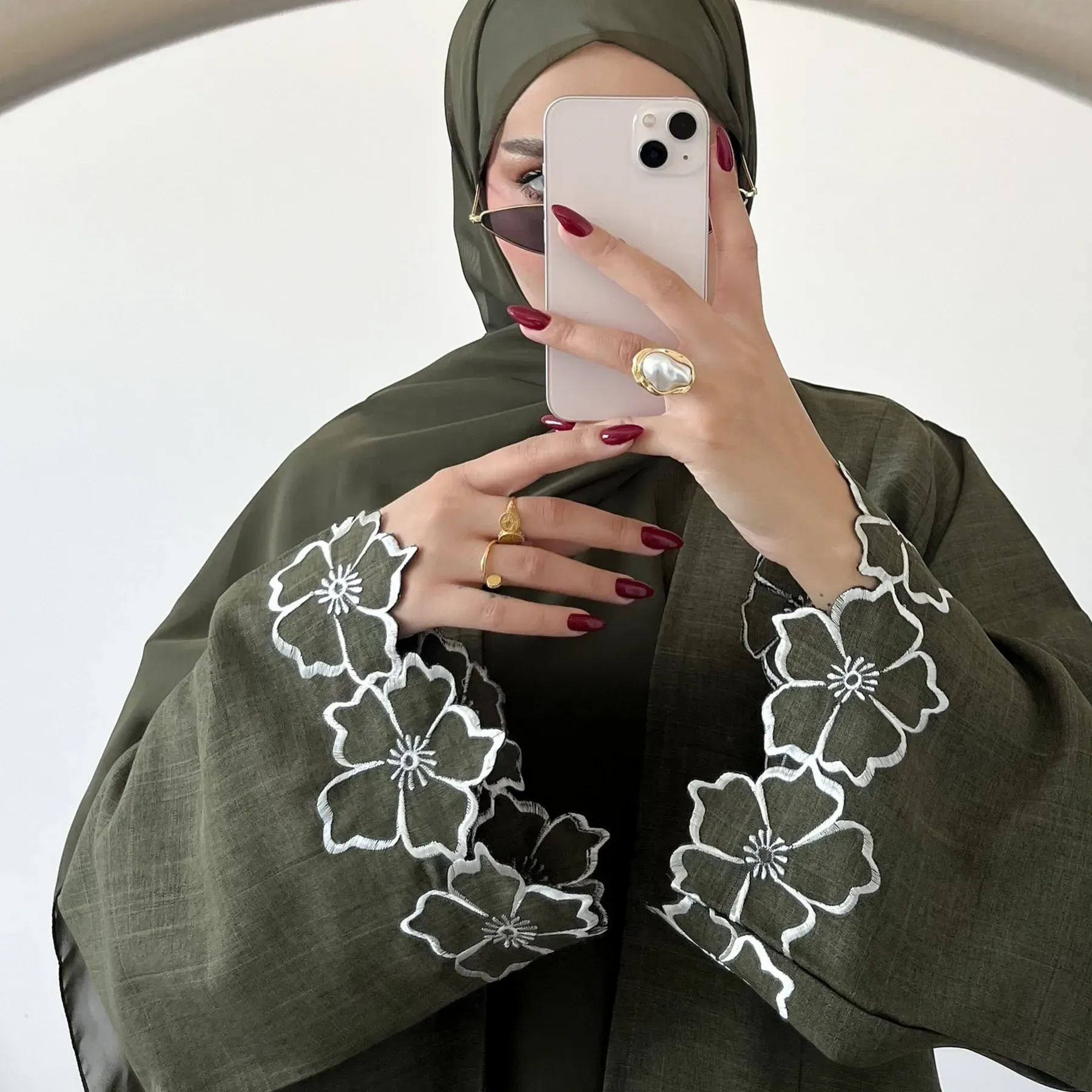 A woman in a green dress is sitting in a chair.