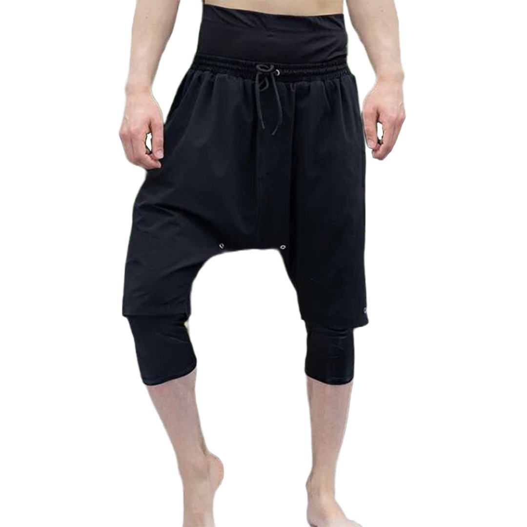 A man is wearing a pair of black harem pants