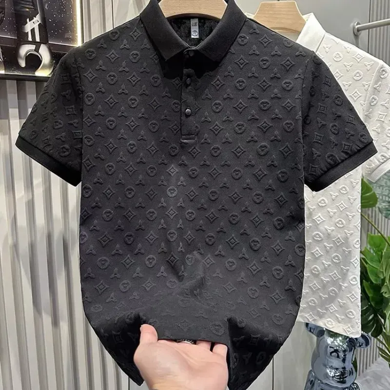 A white polo shirt with a monogram on it is hanging on a hanger.