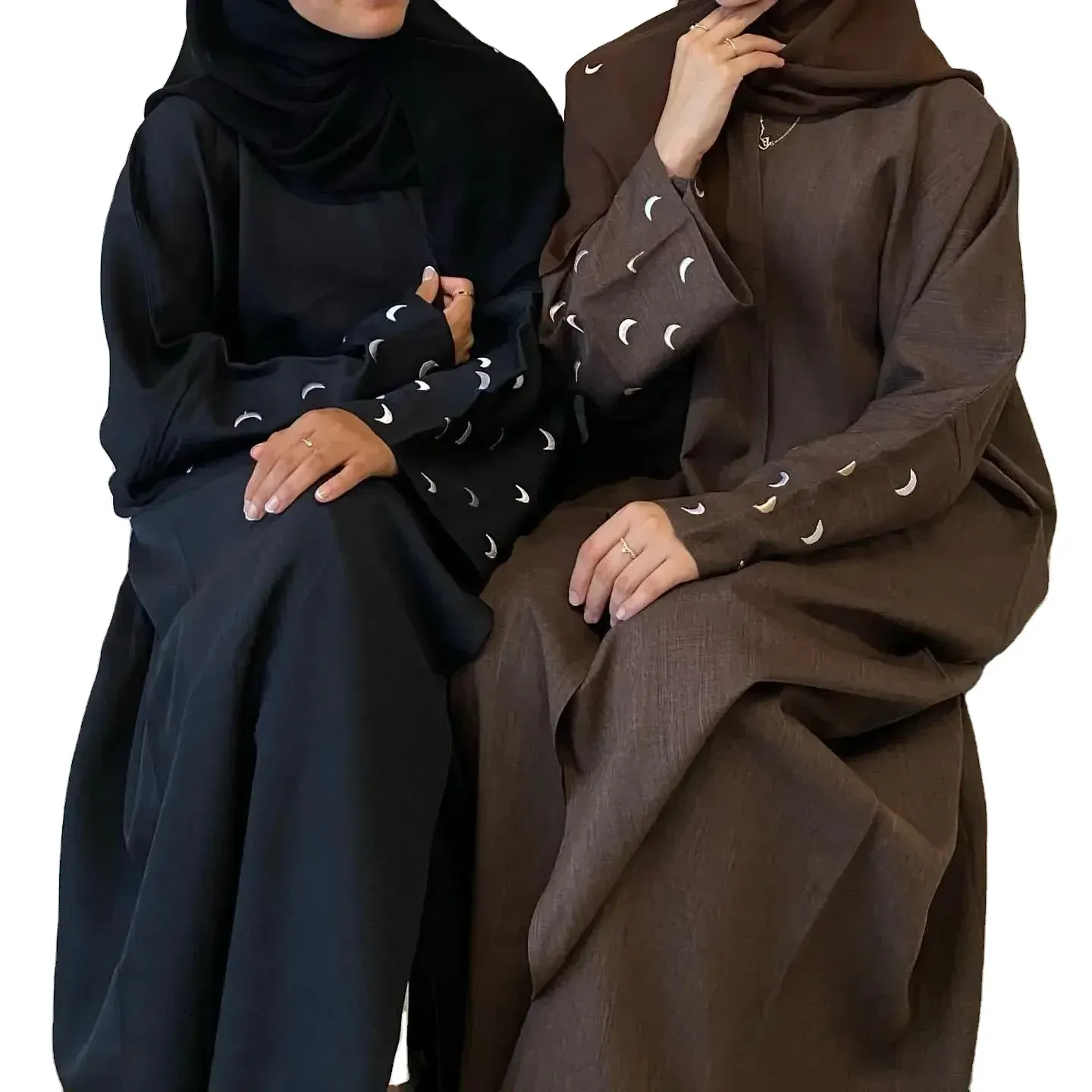 Two women in abayas are sitting next to each other