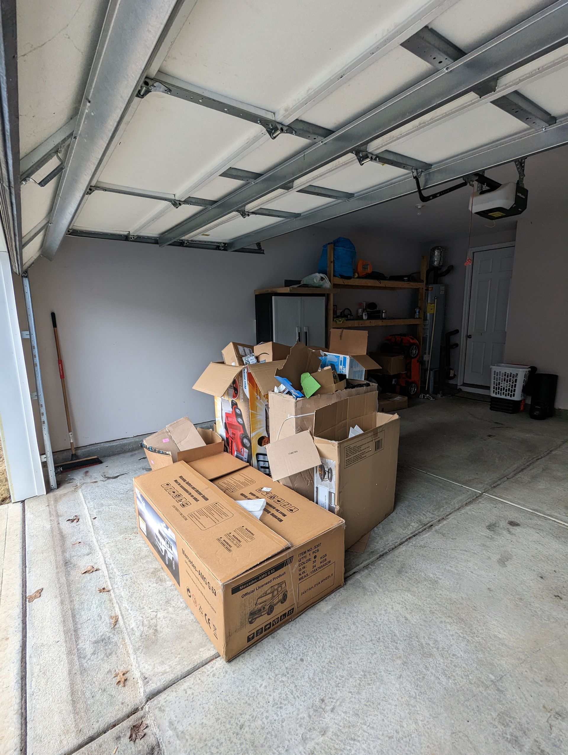 A bunch of cardboard boxes are stacked on top of each other in a garage.