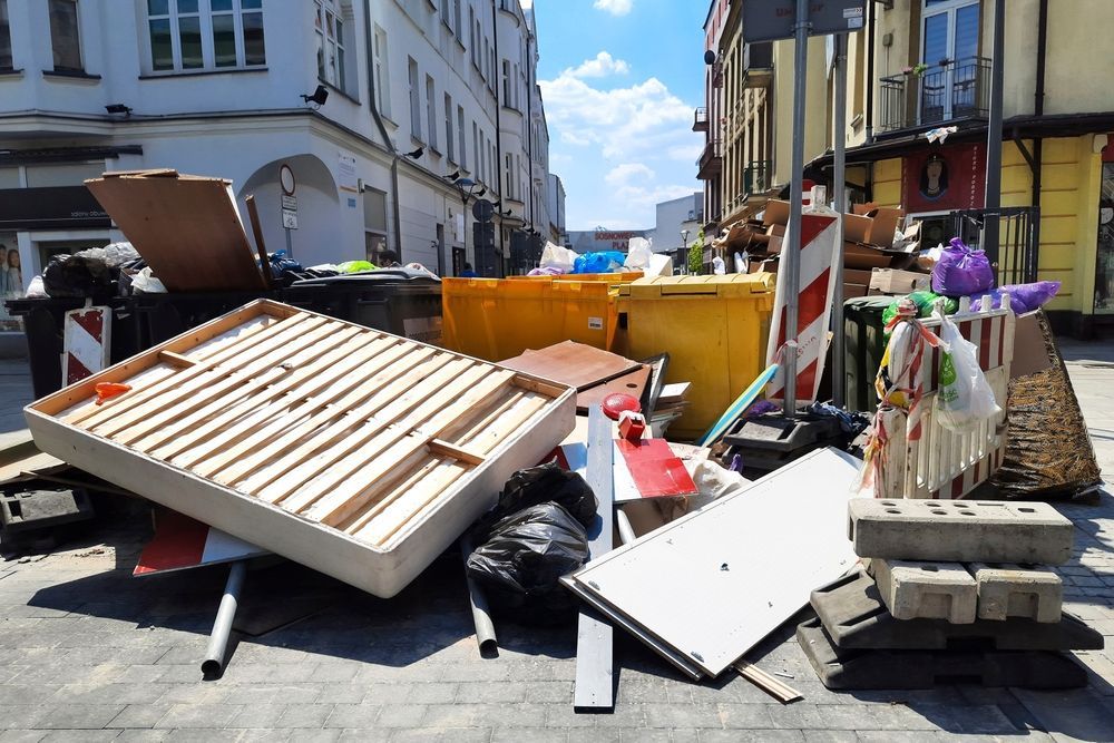 A pile of trash is sitting on the sidewalk in front of a building.