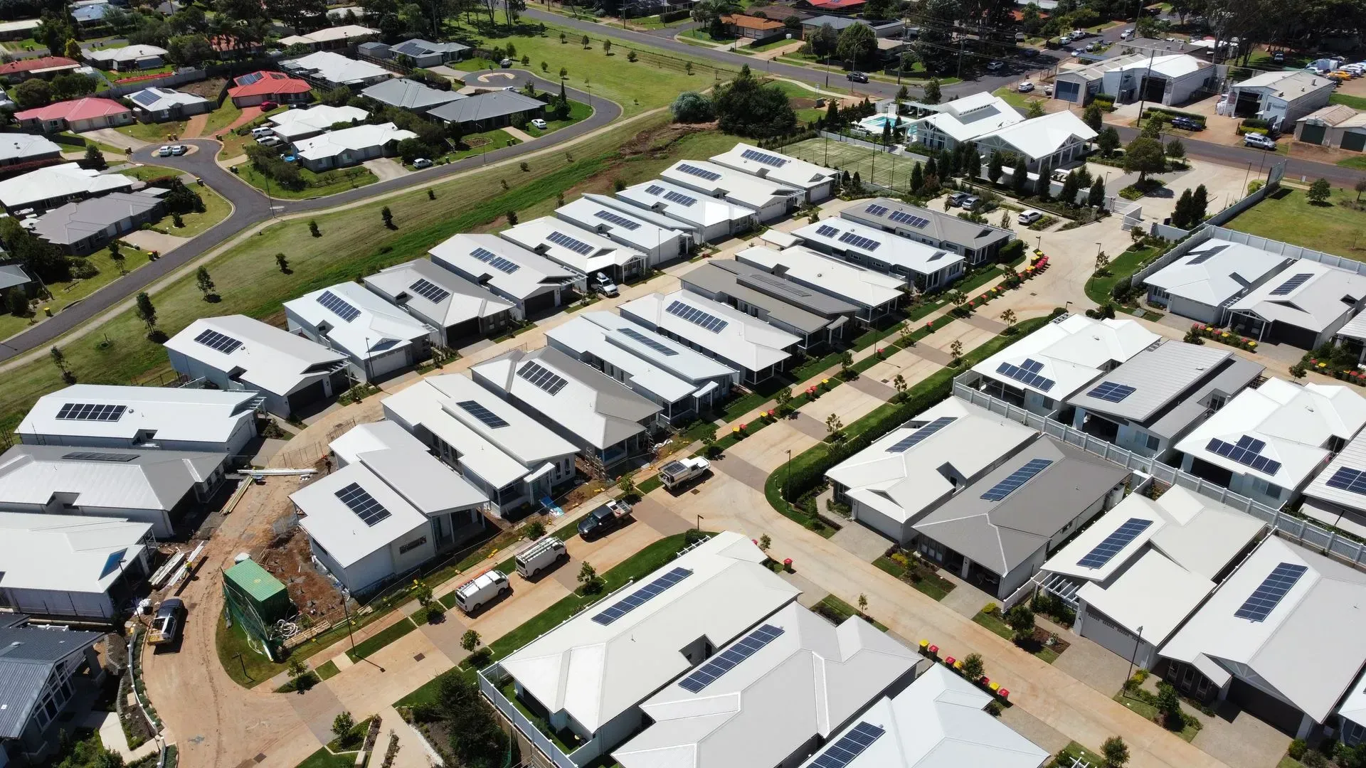 Solar panels installed on a rooftop, arranged in rows, reflecting sunlight.