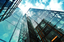 Glass skyscrapers reflecting blue sky and clouds.