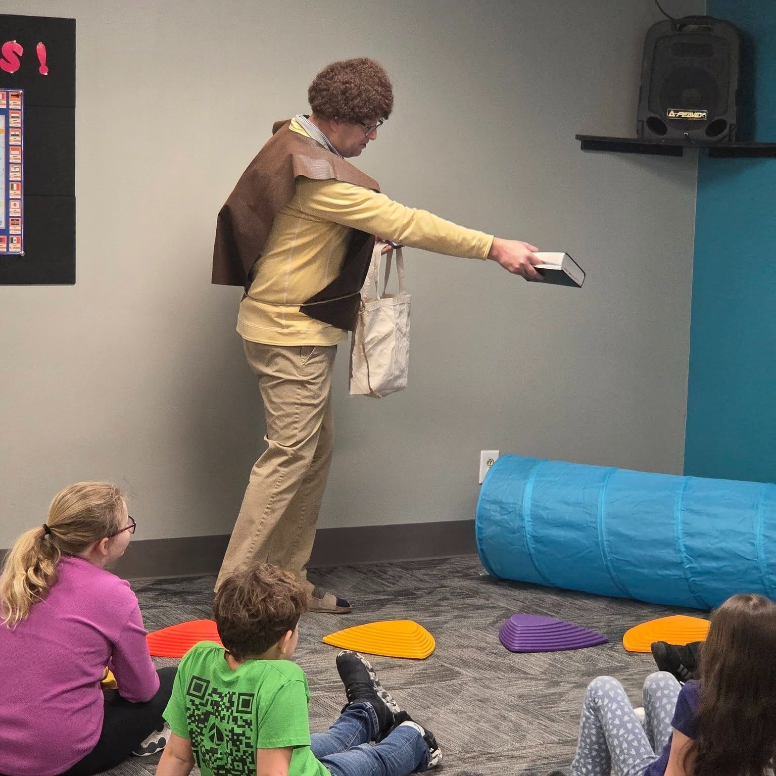 A group of children are sitting around a table 