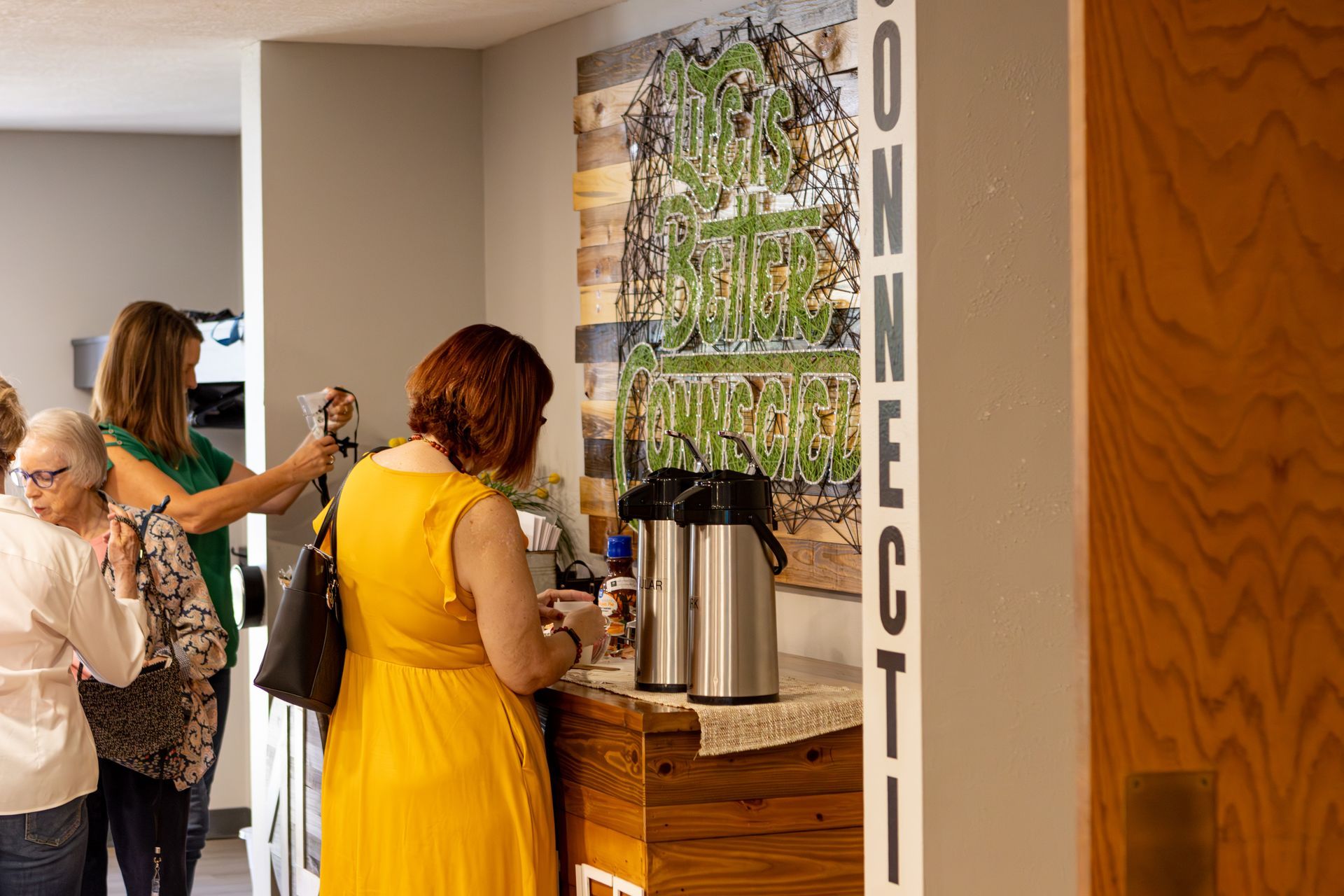 A man wearing a nebraska shirt is talking to a woman at a counter