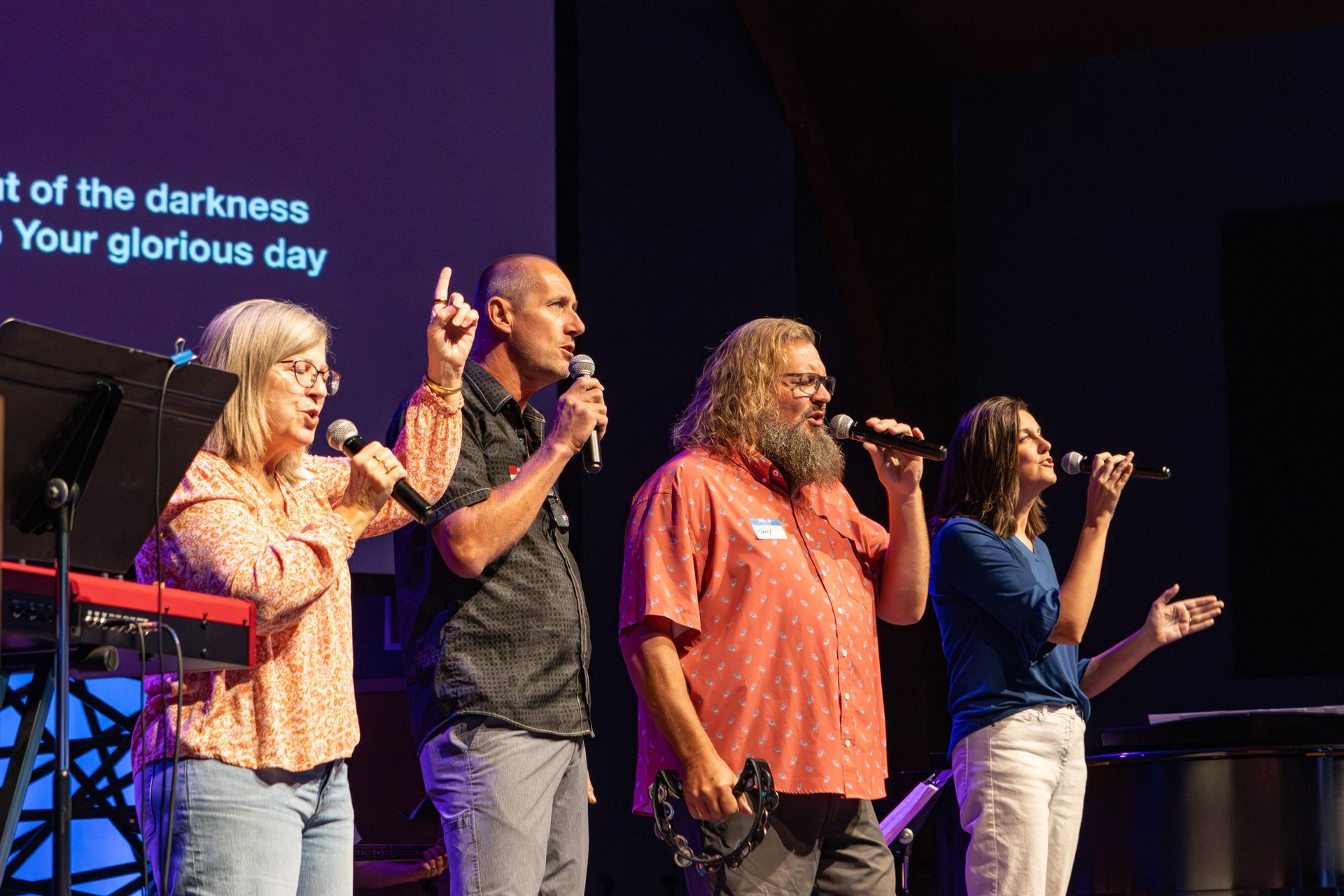 A woman is playing a bass guitar on a stage.