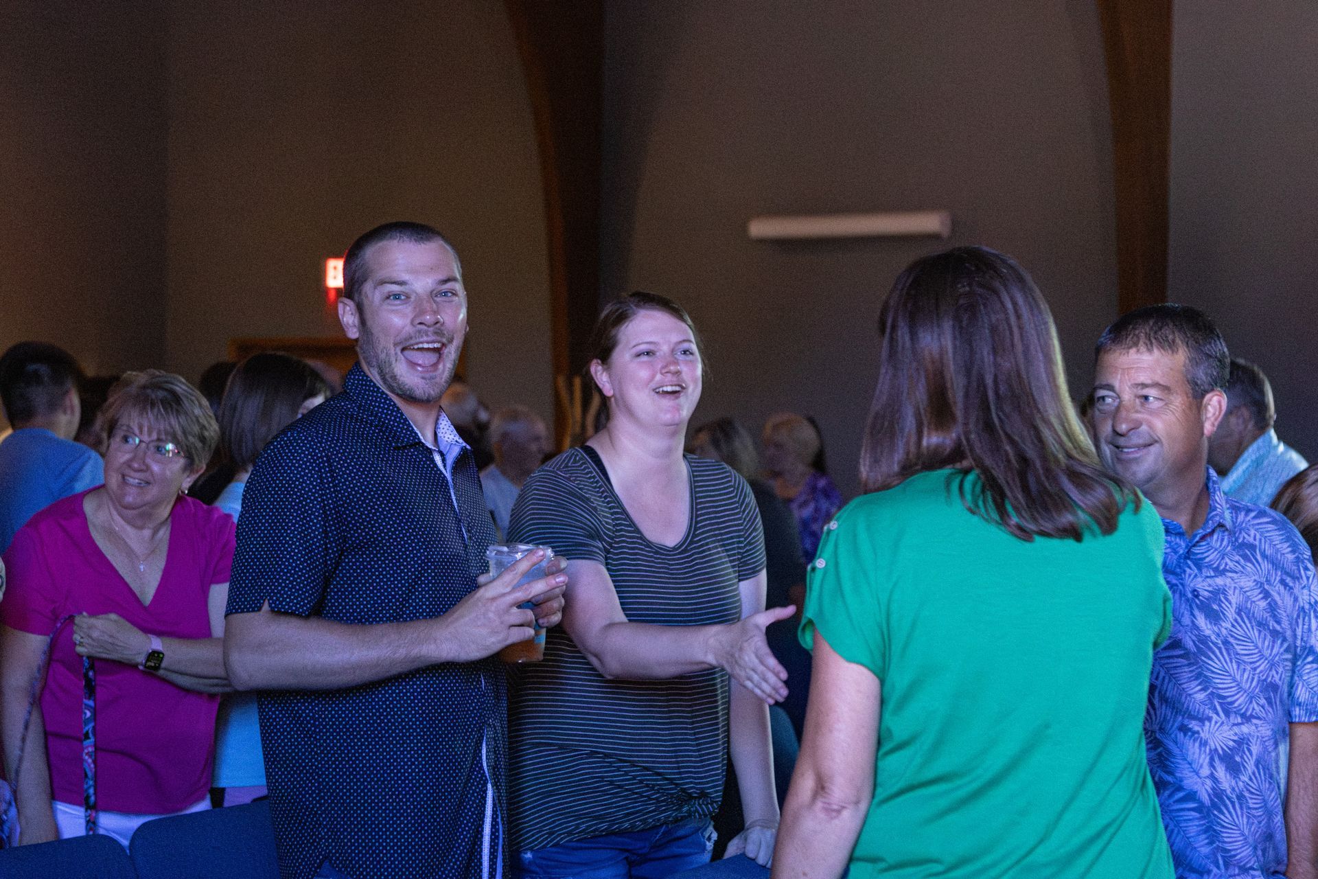 A group of people are singing into microphones on a stage.