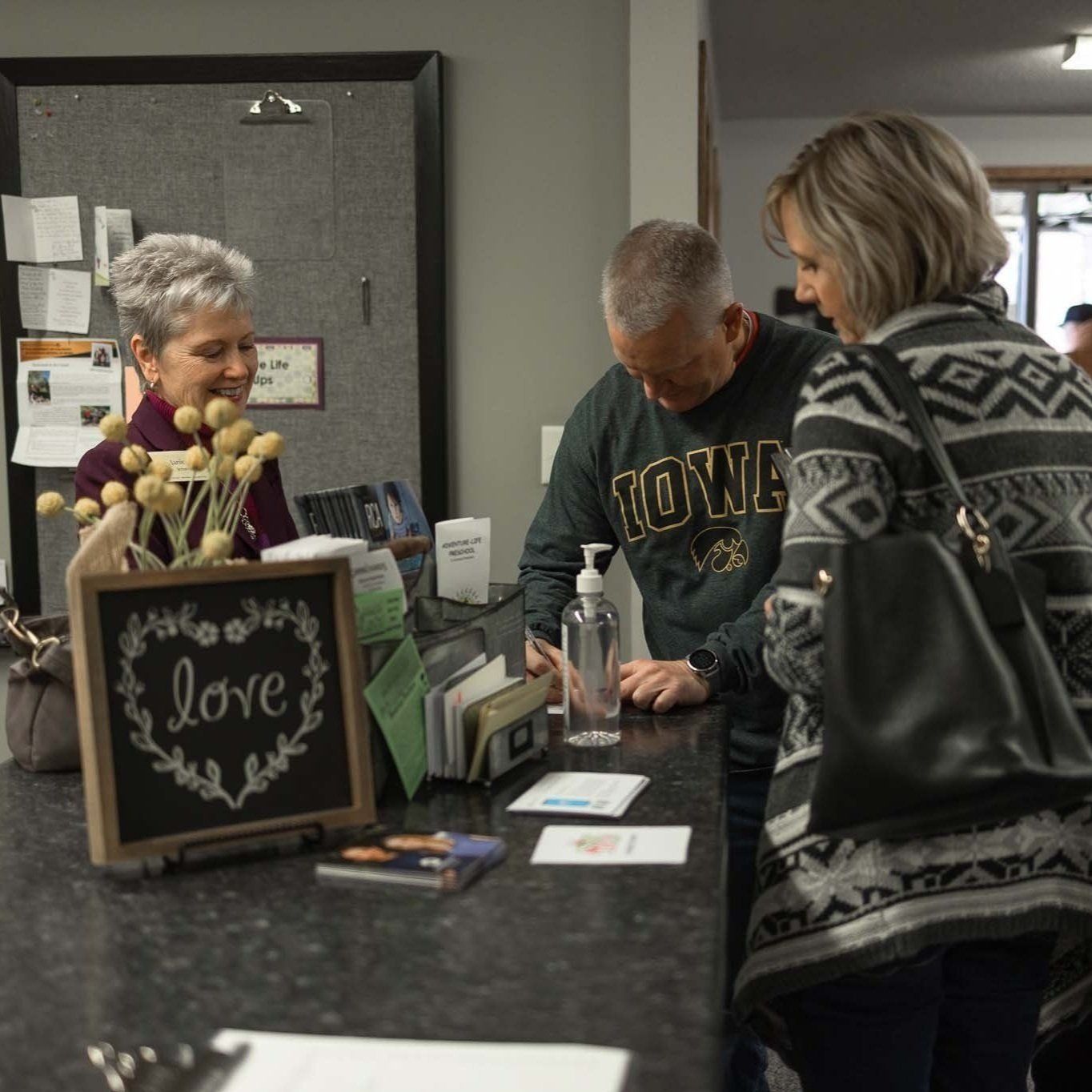 A man is signing in at a welcome counter