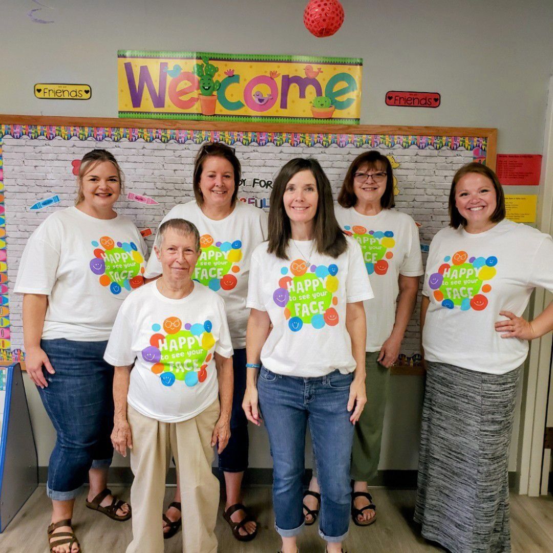 A group of women standing in front of a welcome sign