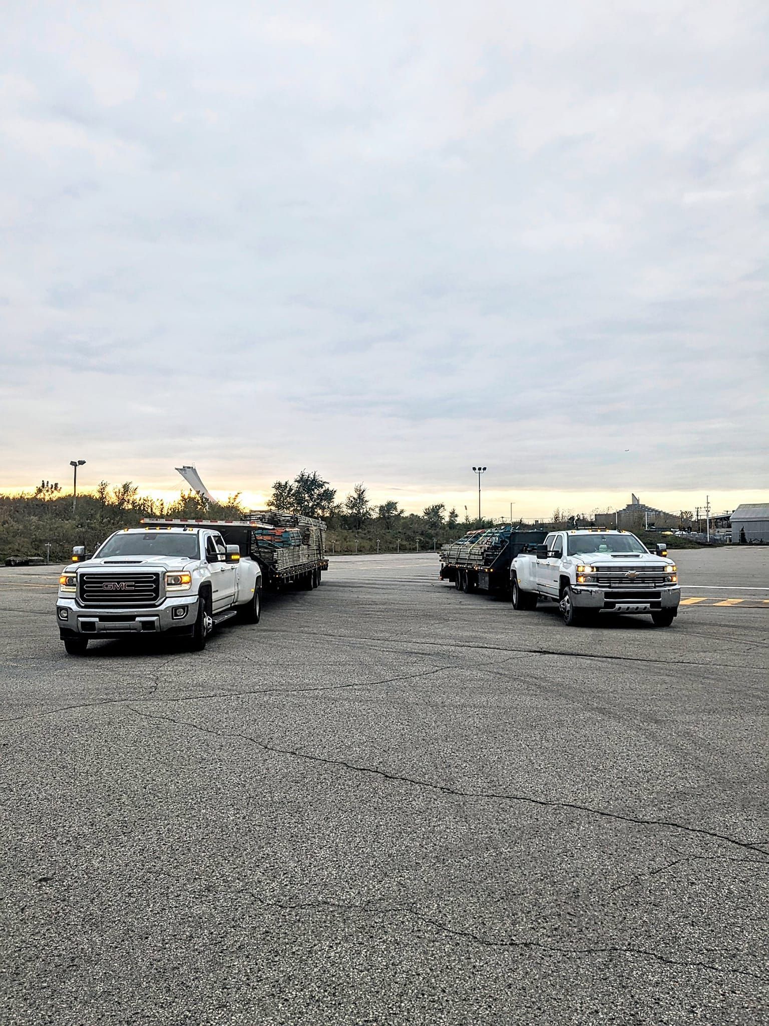 Une rangée de camions est garée sur un terrain en gravier.
