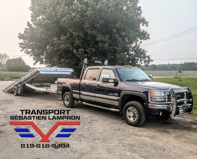 Un camion avec une remorque attachée est garé dans un parking.