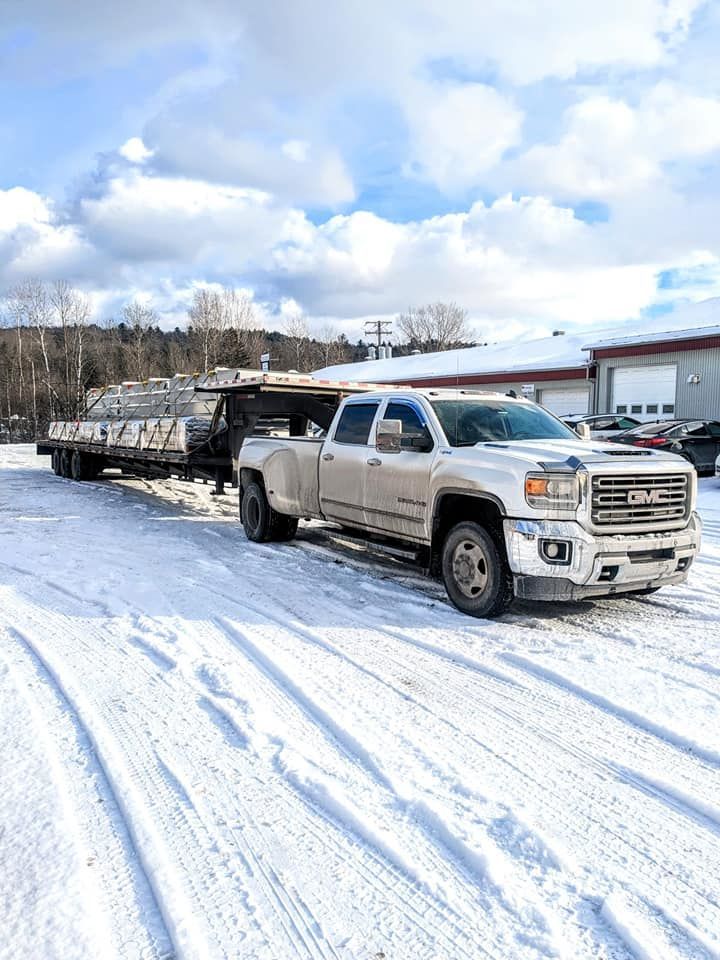Un camion blanc tire une remorque dans la neige.