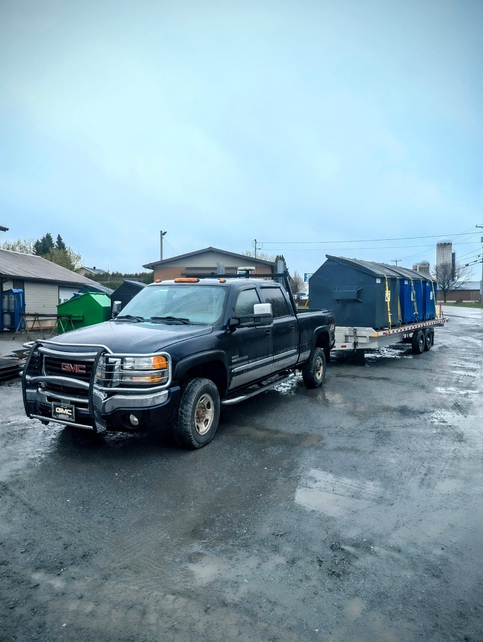Un camion noir avec une remorque attachée est garé sur un parking.