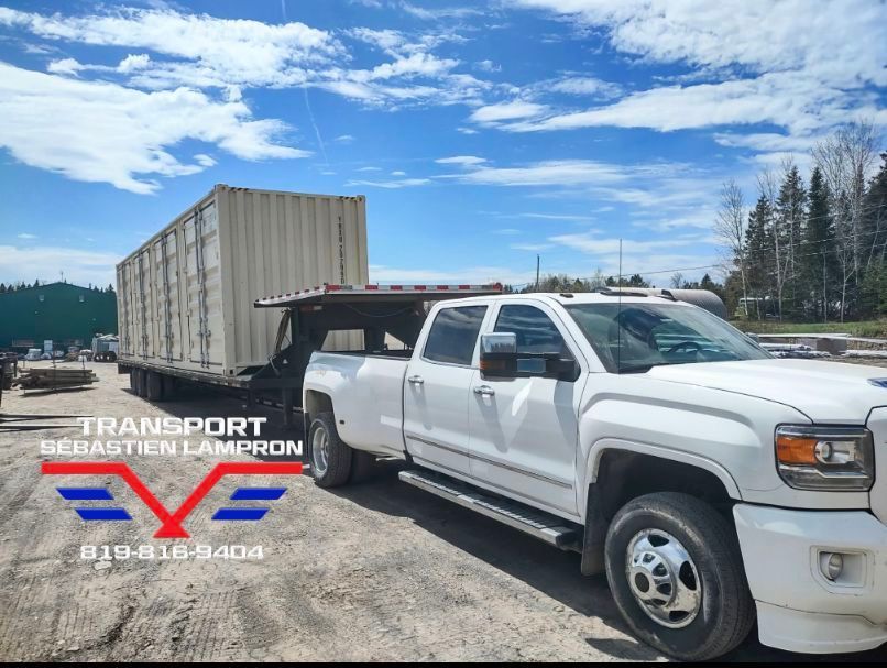 Un camion blanc transporte un grand conteneur à l'arrière.