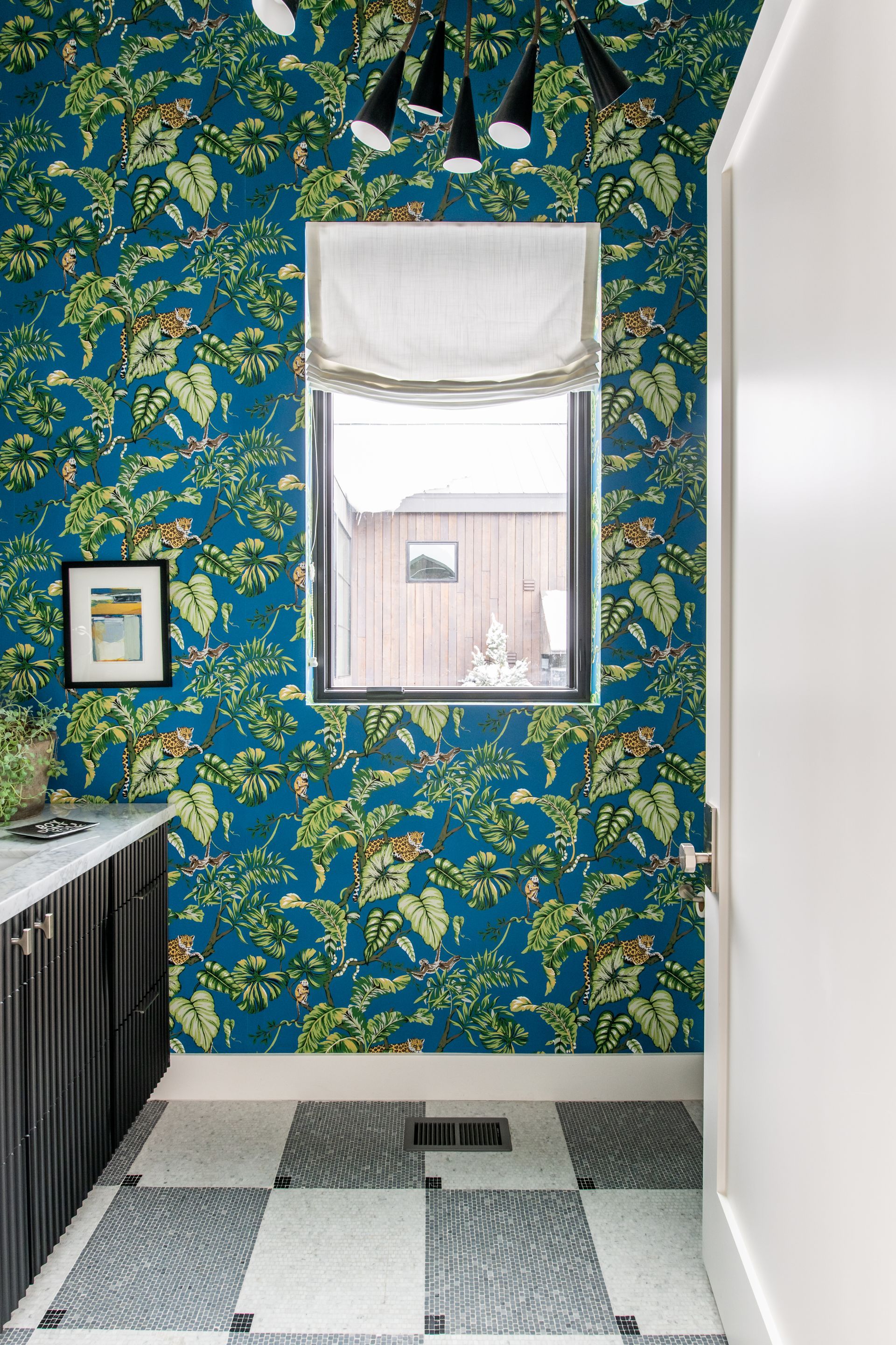 Large window with patterned drapes beside a modern exterior view with palm trees