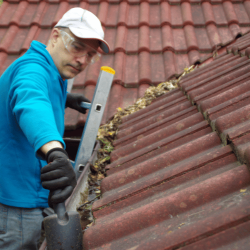 Man cleaning a roof gutter