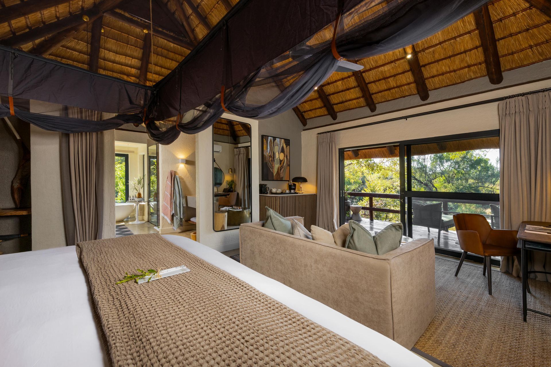 Luxurious safari lodge bedroom with canopy bed, balcony, and forest view. Sabi Sabi LIttle Bush Lodge