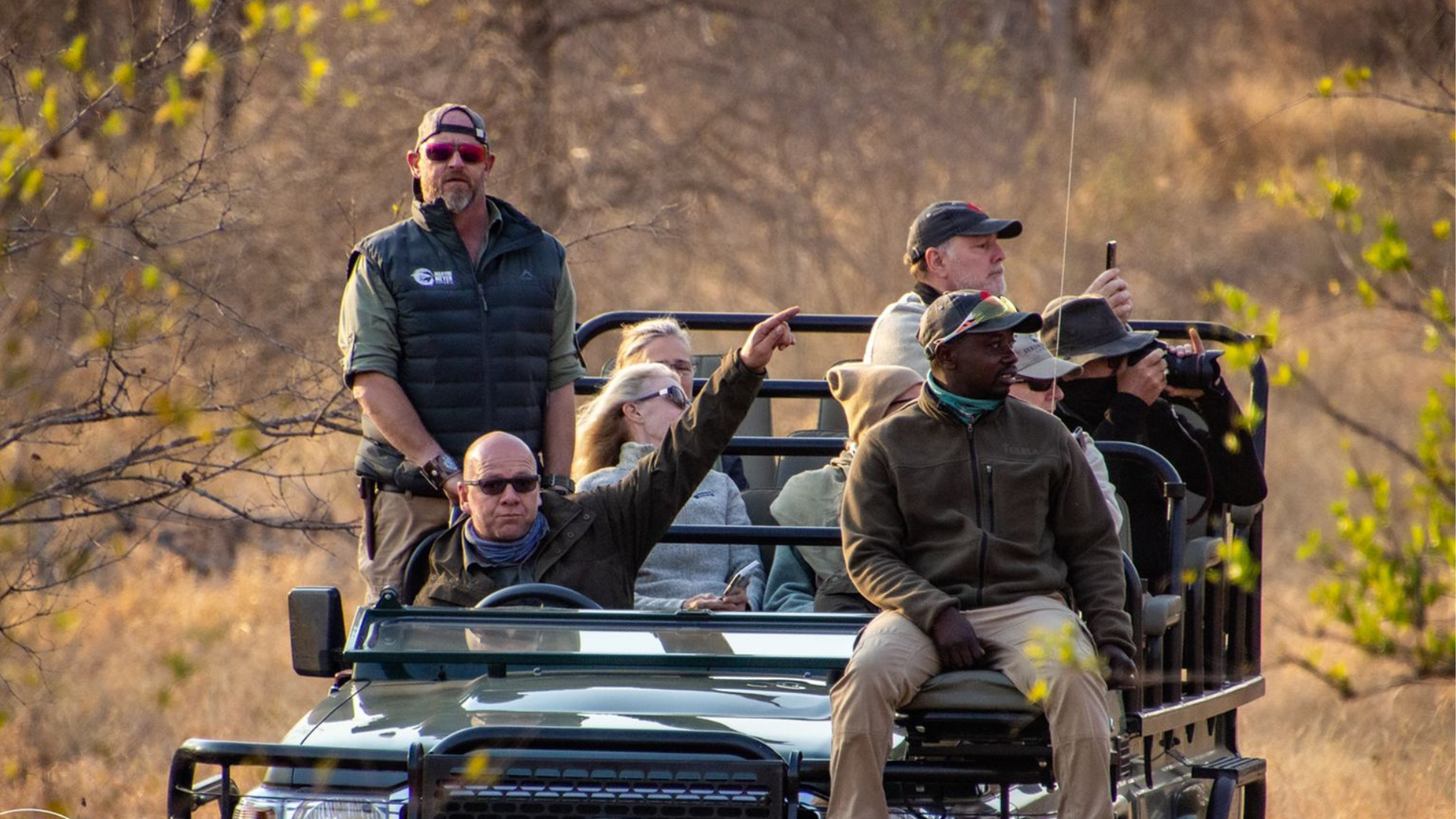 A group of people are riding in a jeep on a safari.