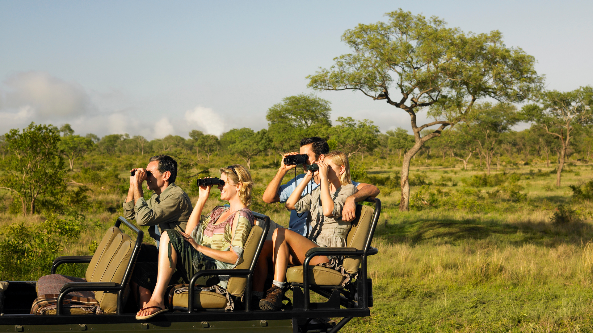 a group of people are sitting in a vehicle looking through binoculars .
