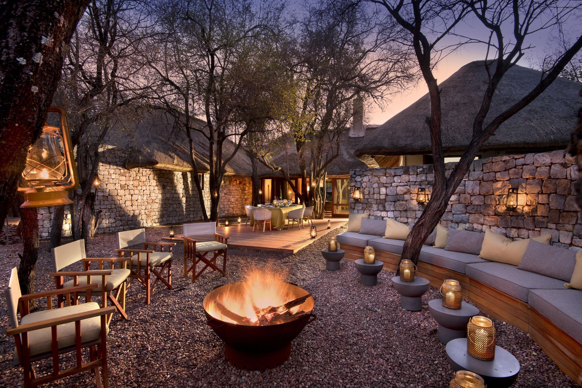 A fire pit is surrounded by chairs and candles Malaria Free Safari Destinations