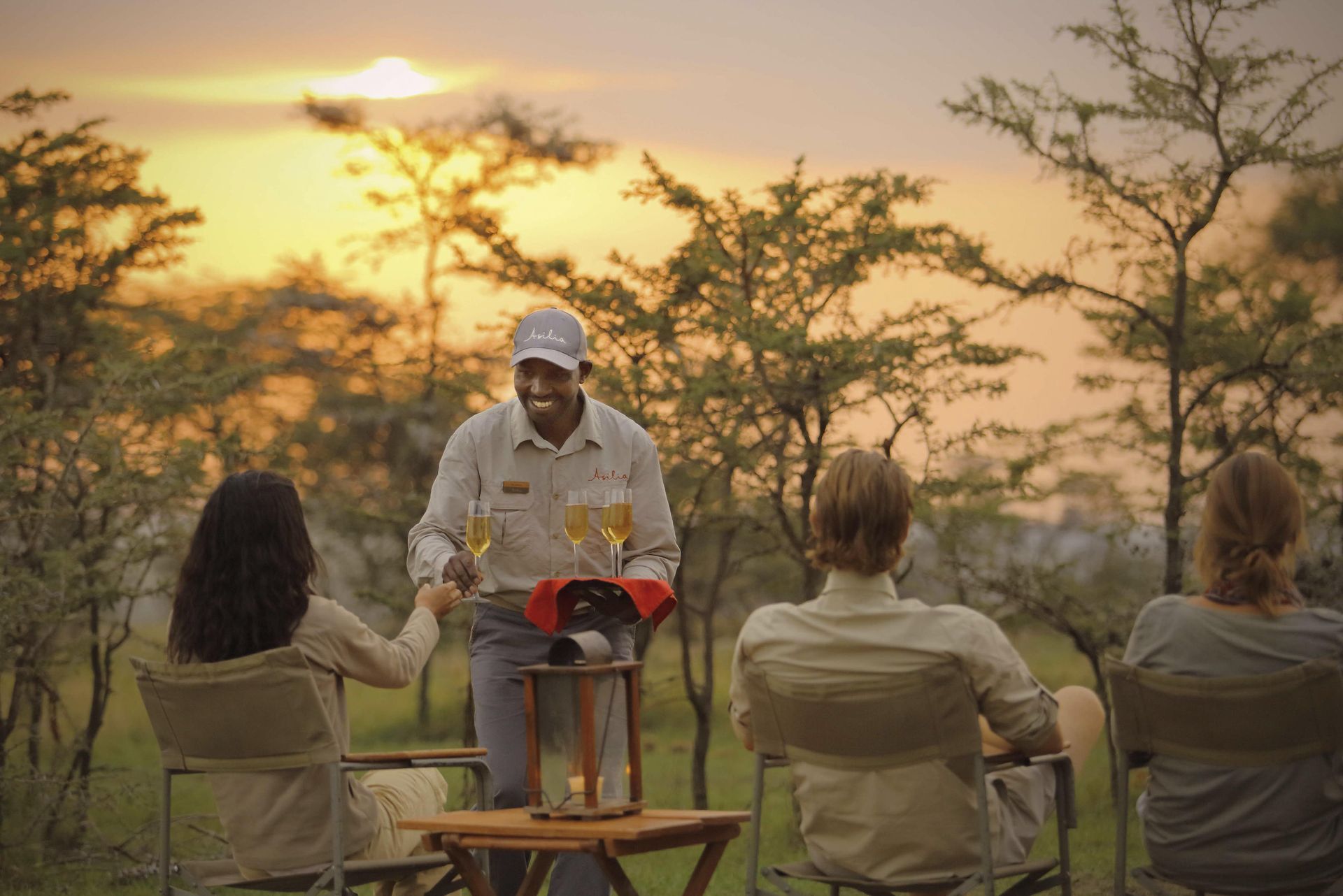 Guests enjoying a private sundowner on safari at Naboisho Camp ©Asilia Africa