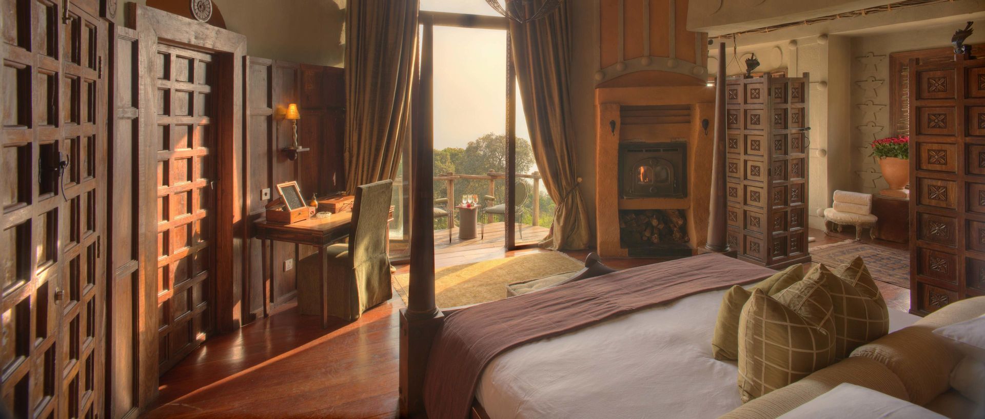 A bedroom with a four poster bed and a balcony. Ngorongoro Crater