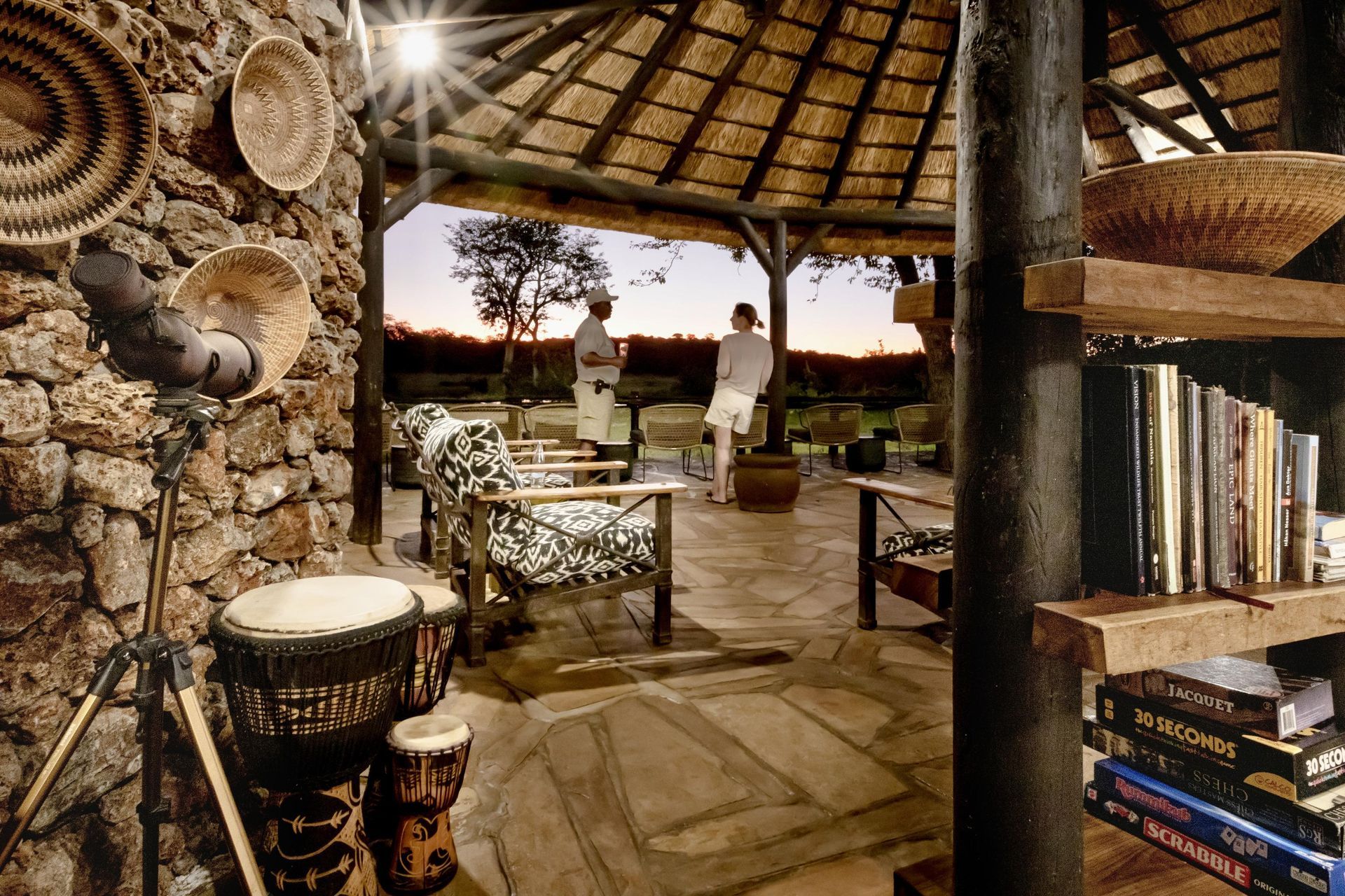 Stone lodge interior with seated people, drums, and books.