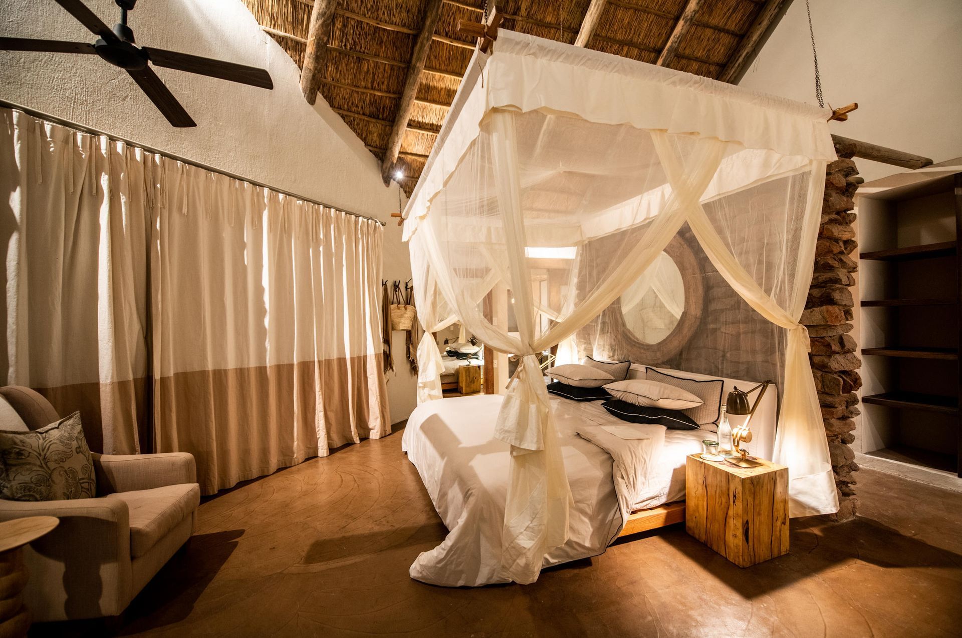 A bedroom with a canopy bed and a ceiling fan. Malaria Free Safari Destinations