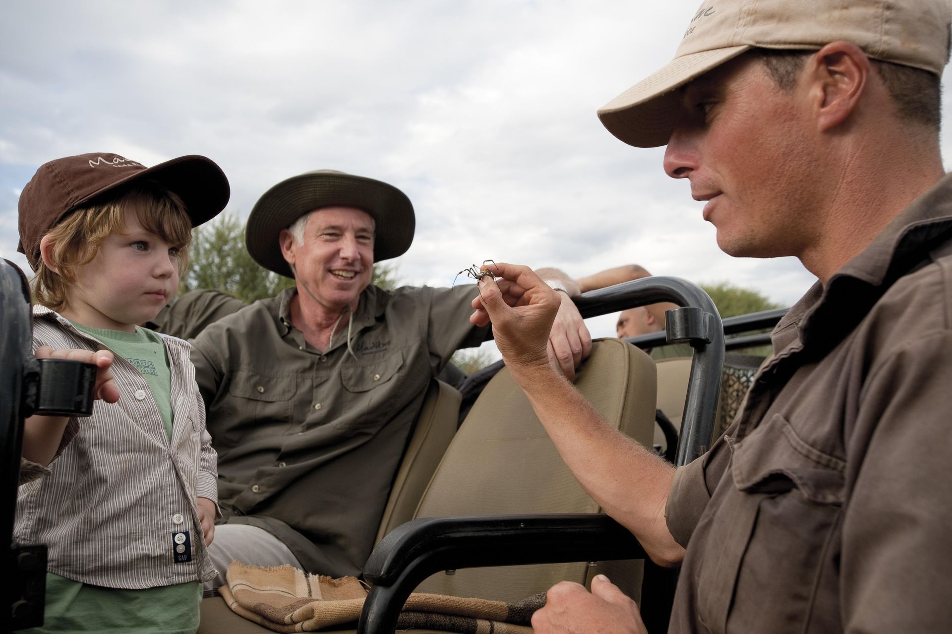 A group of people are sitting in a vehicle talking to each other Family Friendly Safari