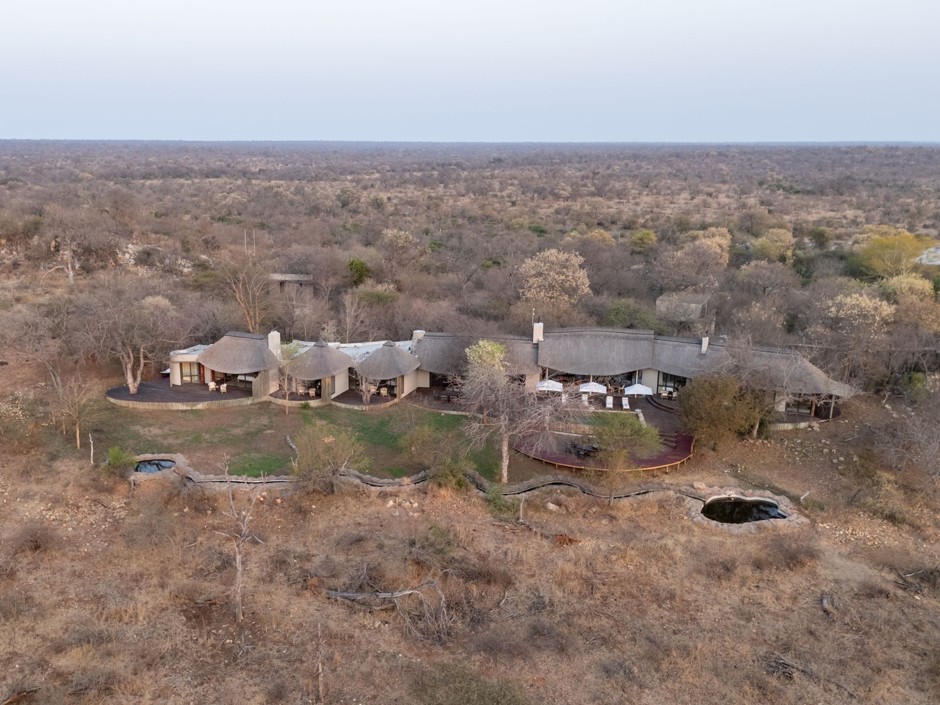 Balcony with mountain view, round table with chairs, lounge seating.