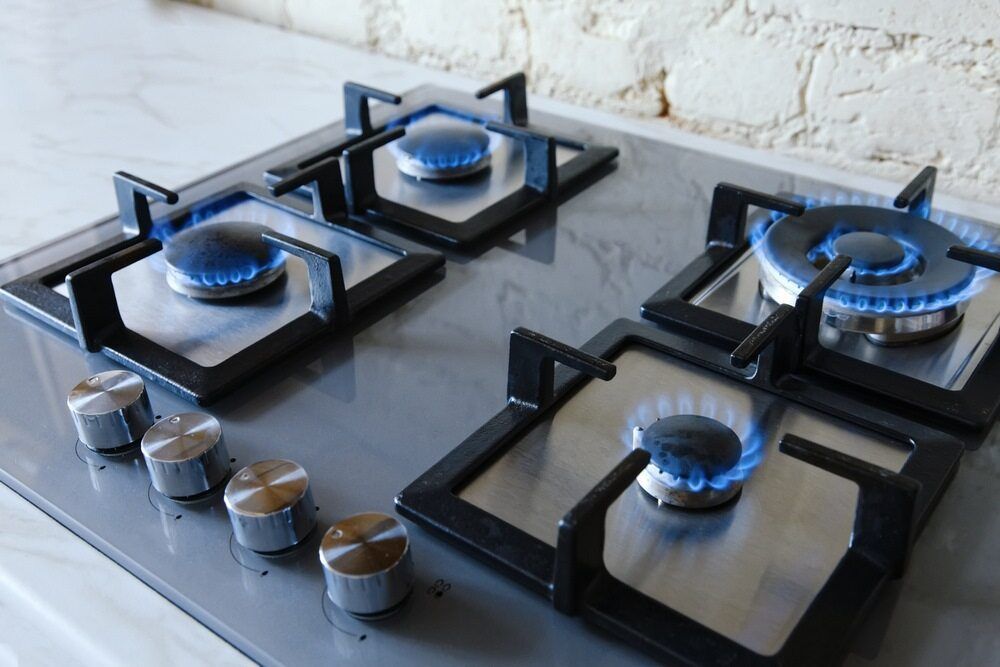 A Gas Stove With Four Burners And Blue Flames On It — Todd Williams Plumbing and Gas Fitting In Forster, NSW