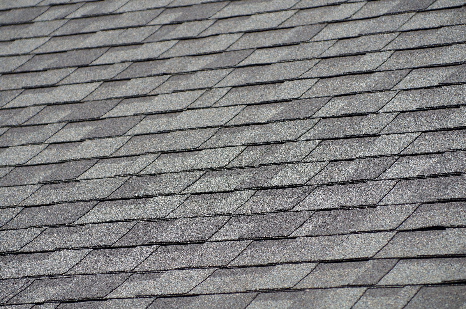 Gray asphalt shingle roof pattern with overlapping rectangular tiles
