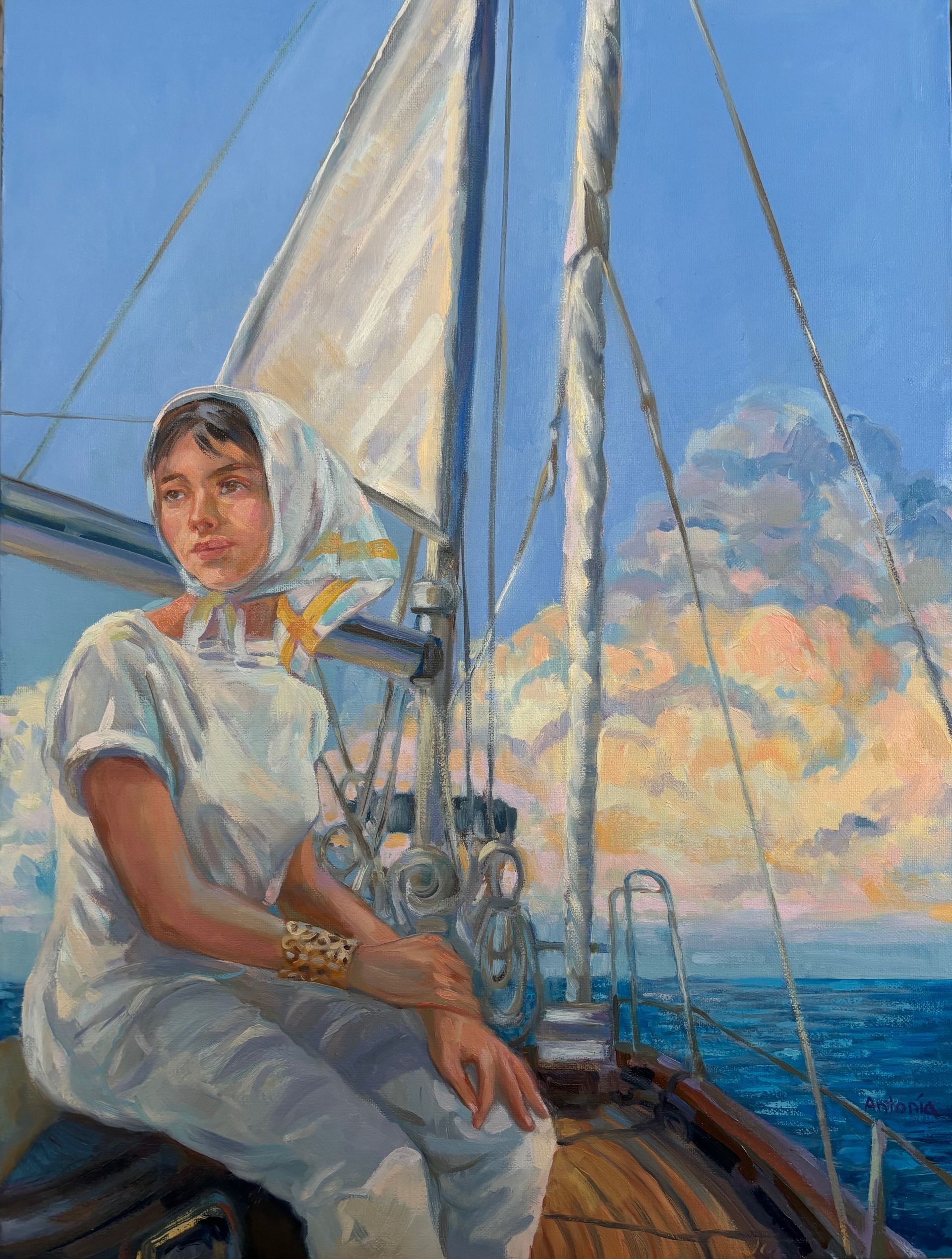 Woman in white on a sailboat, looking out to sea. Blue sky, white sails, and sunset clouds.