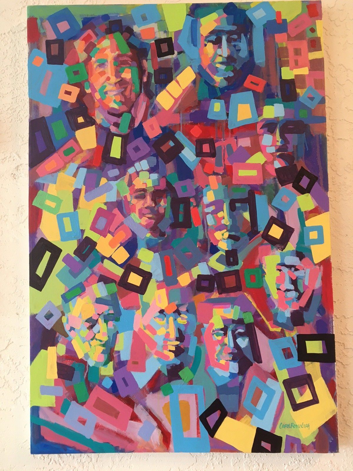 Colorful abstract painting of multiple faces, surrounded by geometric shapes, with varying expressions.