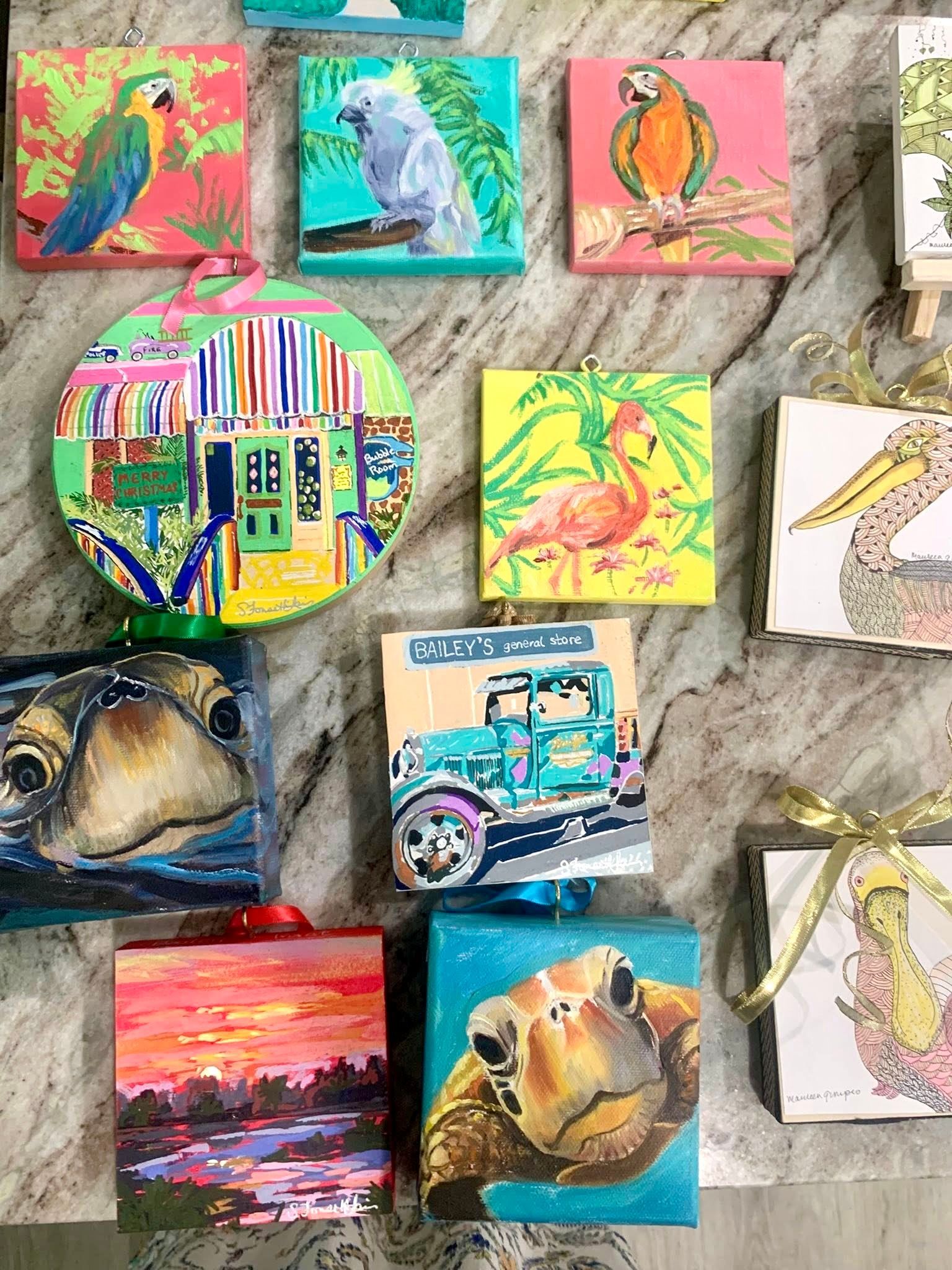 Colorful square and round paintings of birds, animals, a car, and a sunset.