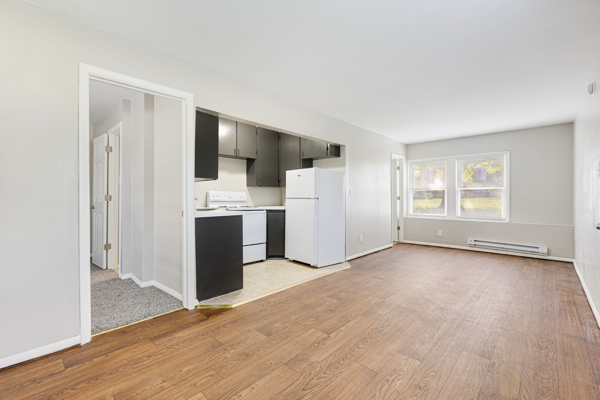 Interior of a newly renovated apartment: kitchen and living space with laminate flooring.