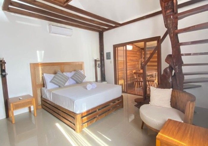 A bedroom with a king size bed and a chair