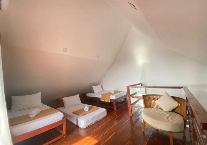 There are three beds and a chair in the room.