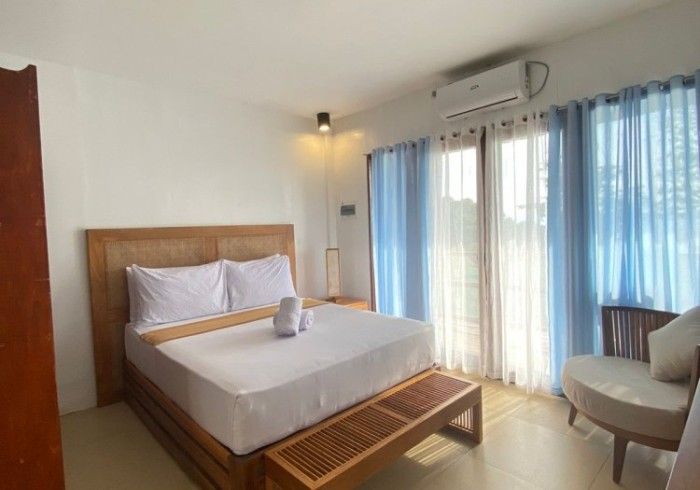 A bedroom with a king size bed and blue curtains.