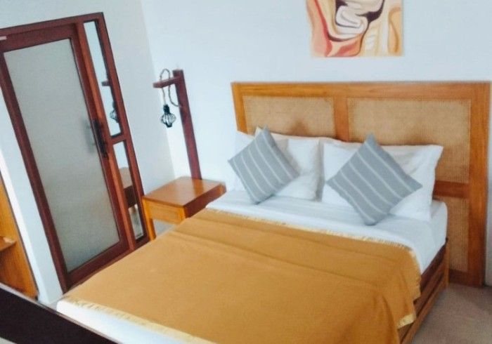 A hotel room with a bed and a nightstand