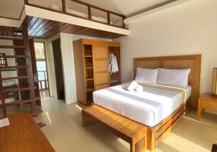 A hotel room with a bed and a staircase