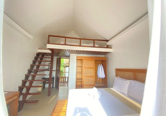 A bedroom with a loft bed and stairs