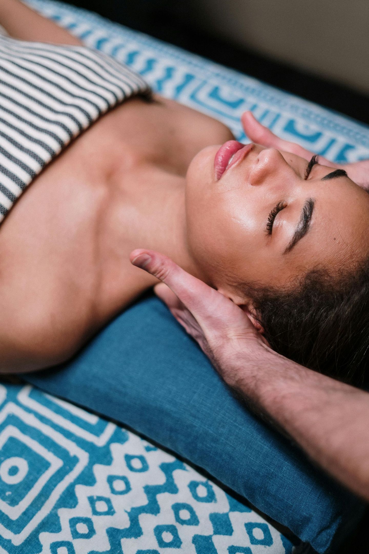 A woman is laying on a bed getting a massage from a man.